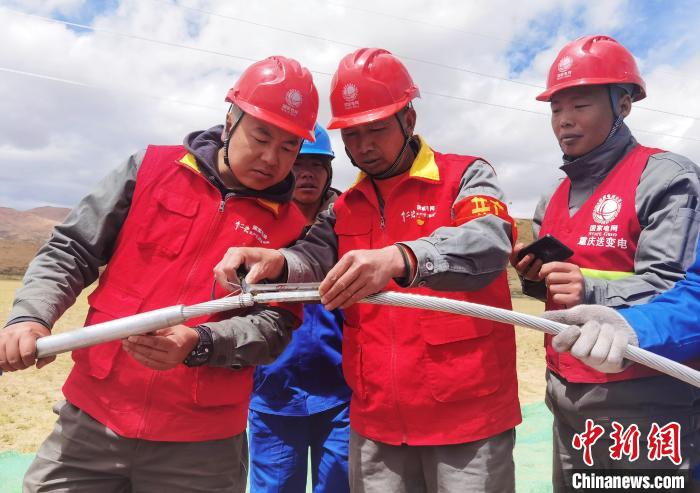 圖為阿裏與藏中電網聯網工程包11標段項目部員工正在測量導線壓接尺寸。　張弛 攝